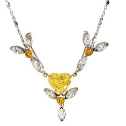 2.01ct Heart Shaped Fancy Intense Yellow Diamond. Surrounded by three flower petals with deep orangy yellow diamonds and white marquise diamonds, 2.07ctw. Made in 18K WG.